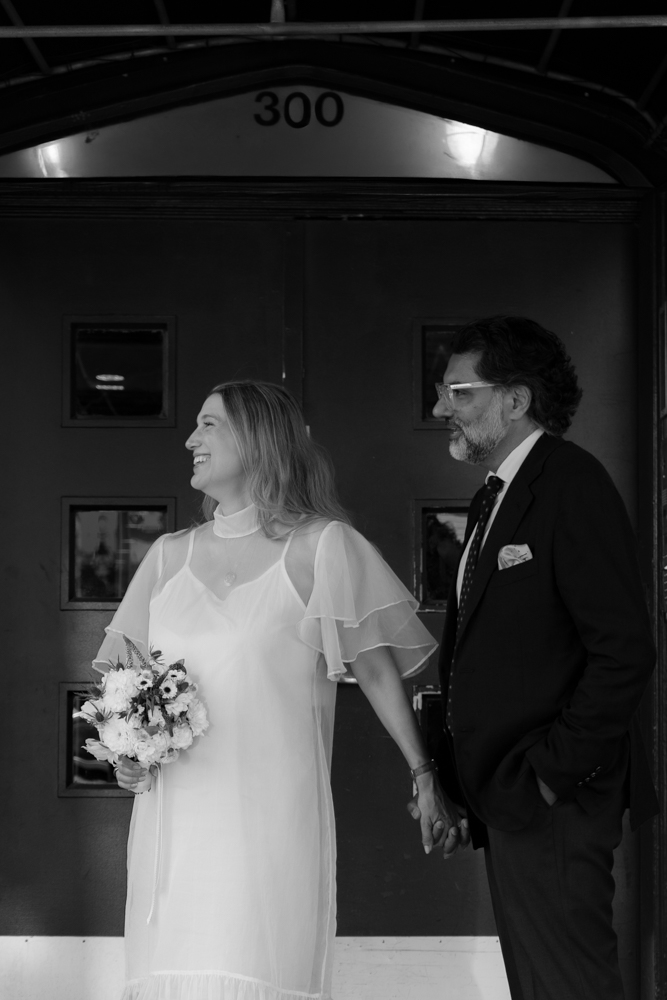 Couple portrait outside their first apartment together for their elopement, taken by stef reyes photo.