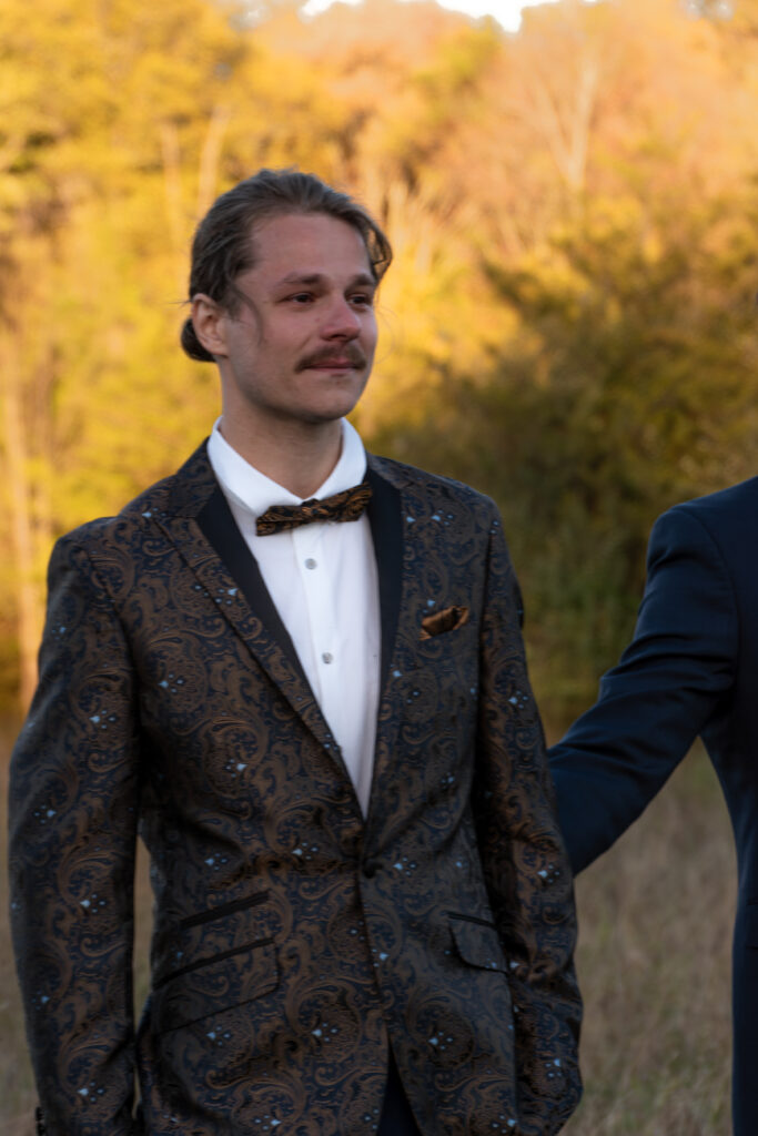 groom watches bride go down the aisle during a hudson valley wedding in the middle of fall, taken by stef reyes photo 