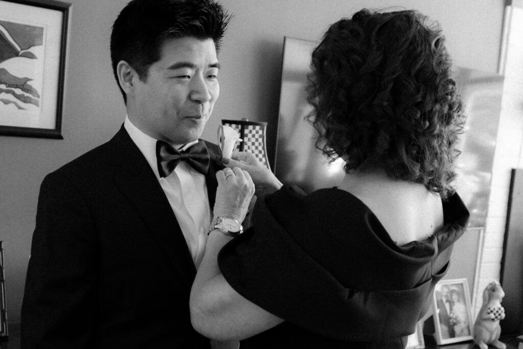 groom getting ready with mother-in-law helping with final details by stef reyes photo in westchester.