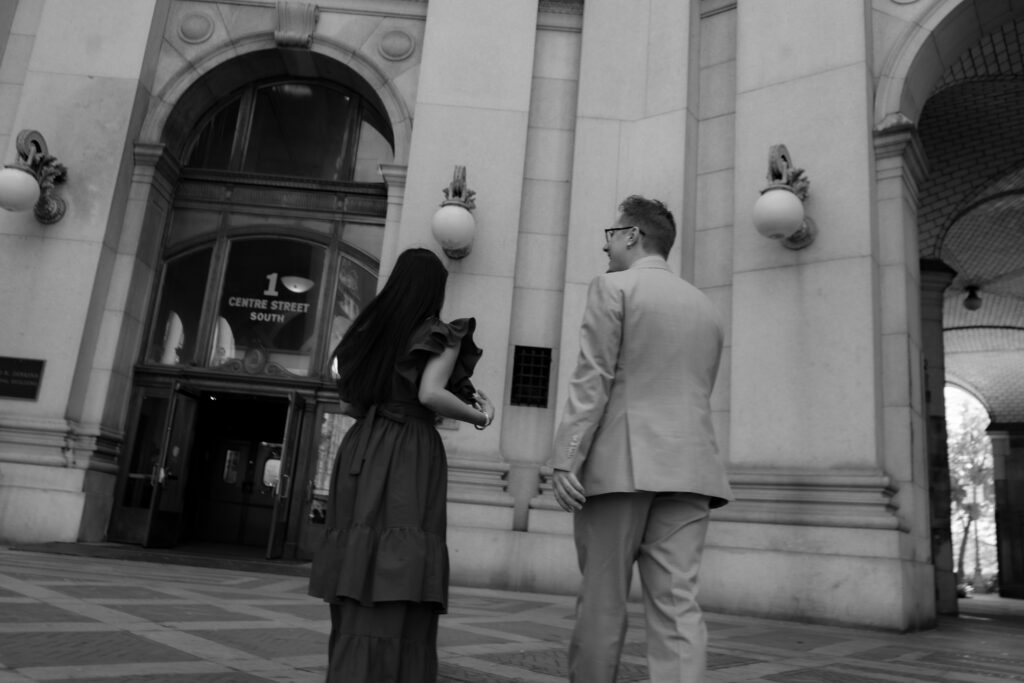 black and white portrait of couple walking near municipal buildings after manhattan city hall elopement, stef reyes photo. 